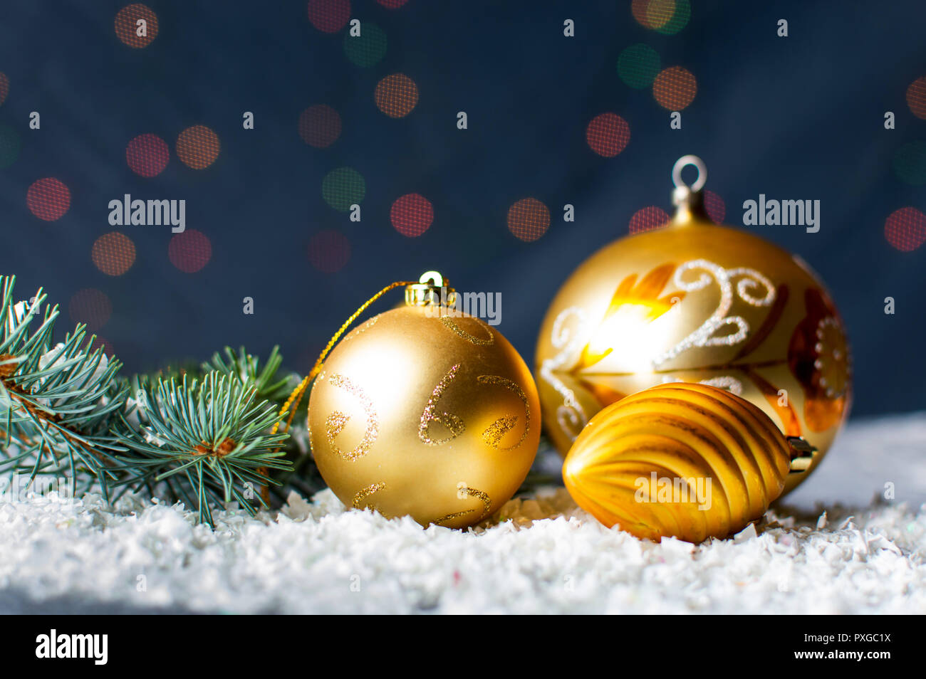 Golden Christmas ornaments and fir branch with festive background Stock Photo