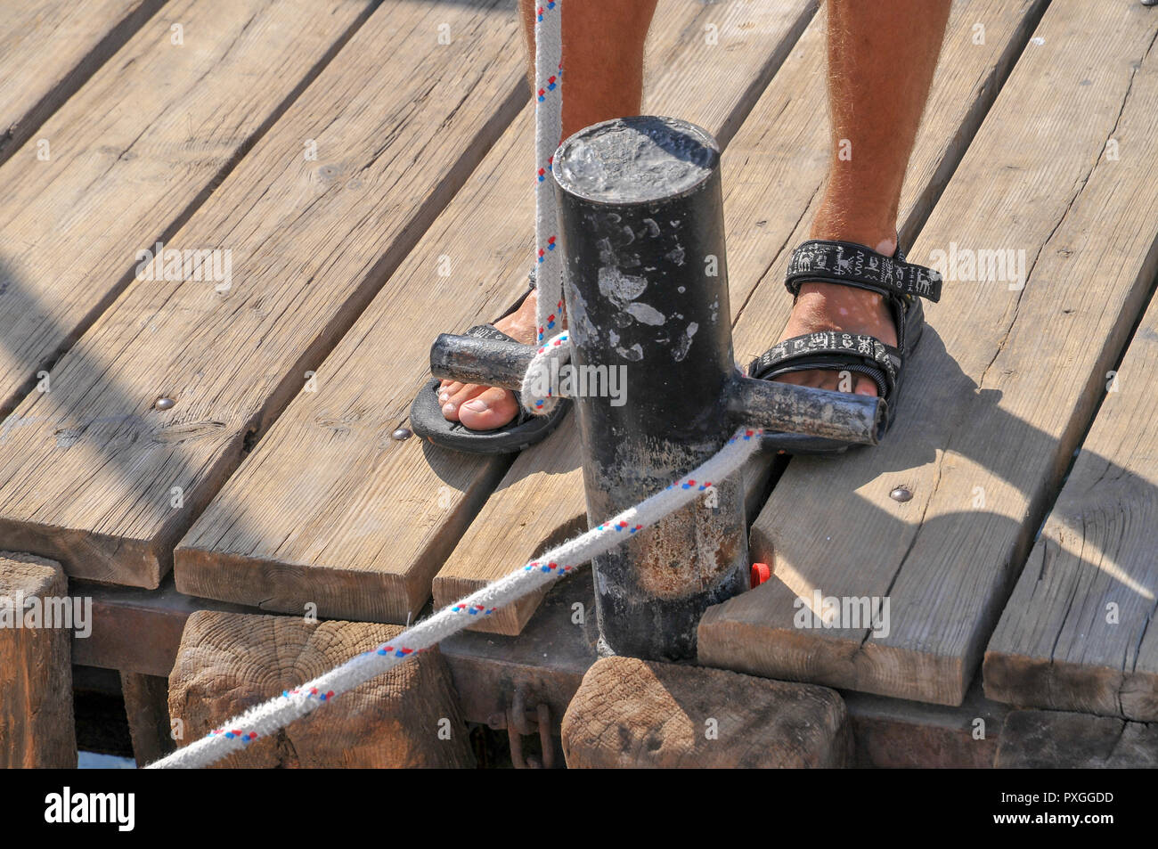 Securing a boat to the jetty with rope Stock Photo - Alamy
