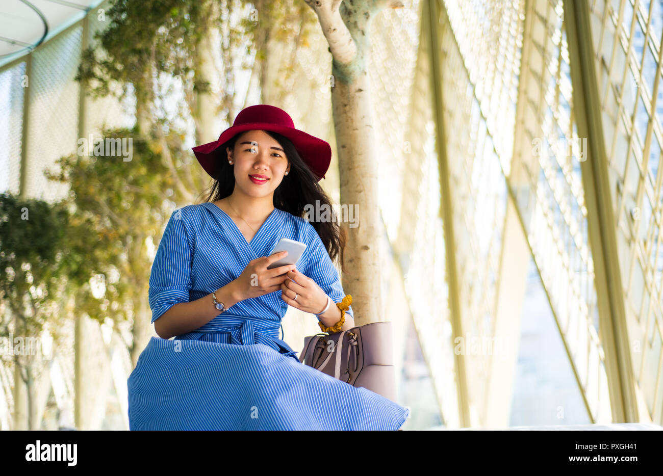 Fashionable Asian girl using phone on a balcony outdoors Stock Photo ...