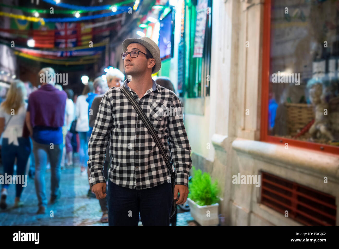 Young serious man looking right on colorful street at night Stock Photo