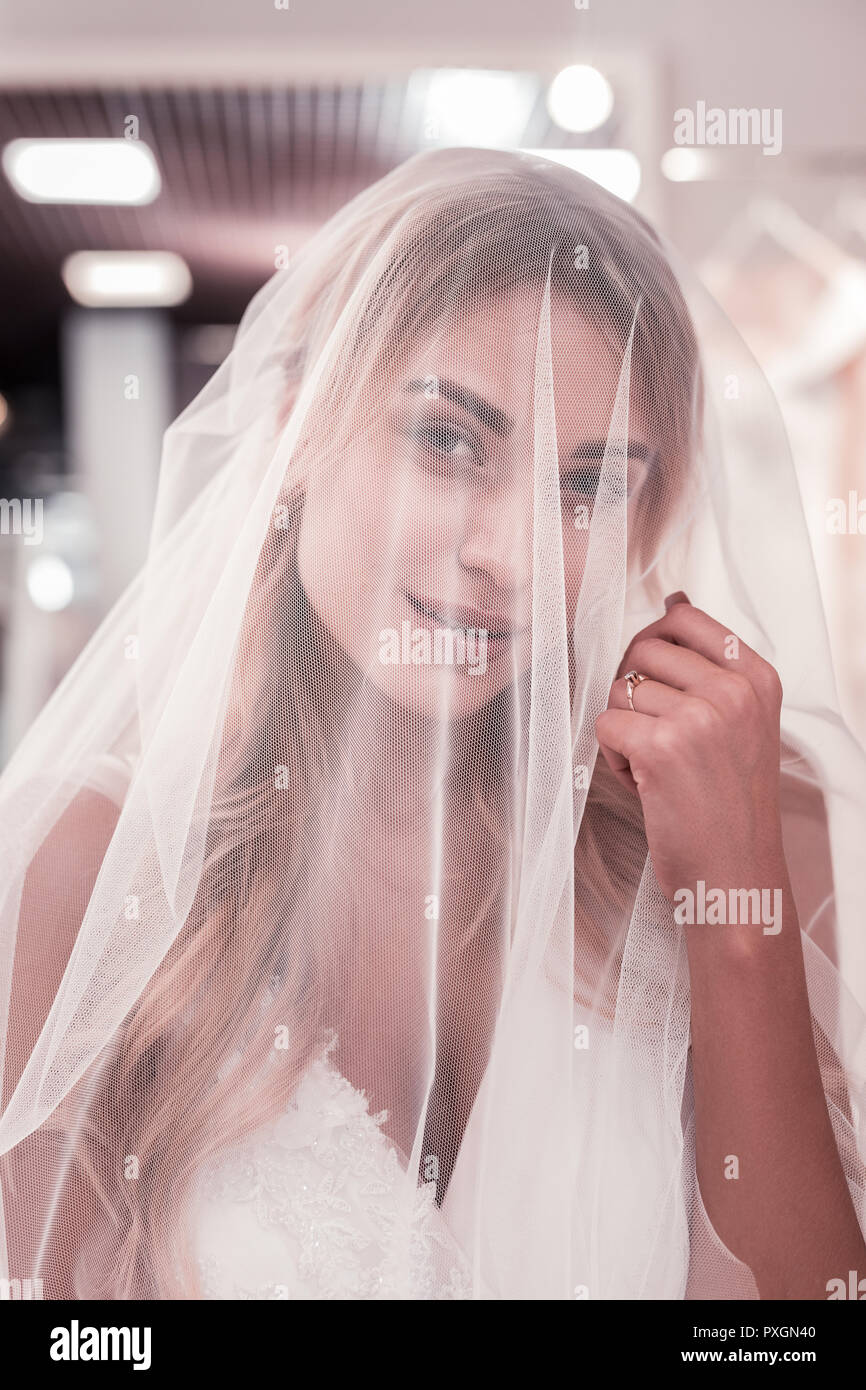 Pleasant nice young woman touching her veil Stock Photo