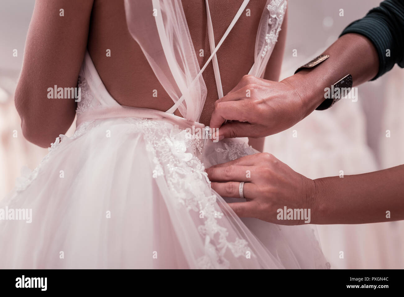 Close up of a wedding dress being fastened Stock Photo