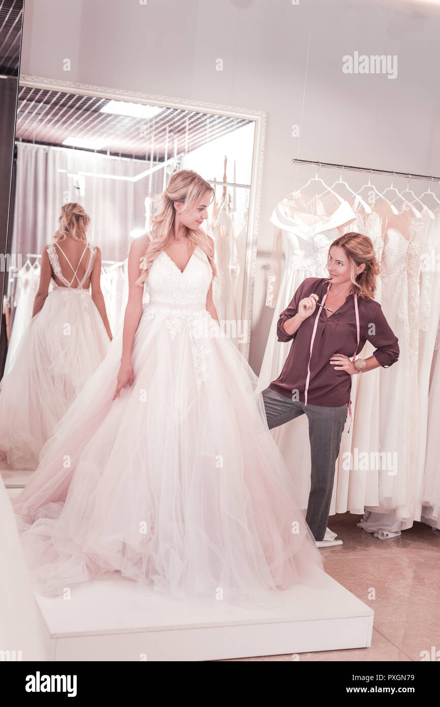 Professional female tailor looking at the bride Stock Photo