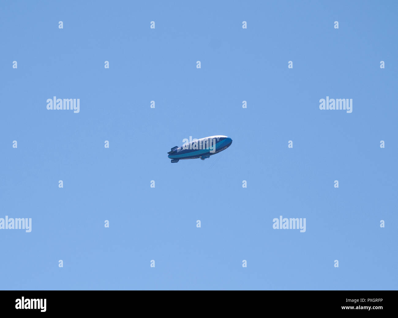 Advertising blimp for Direct TV circles overhead of a city in North Florida. Stock Photo