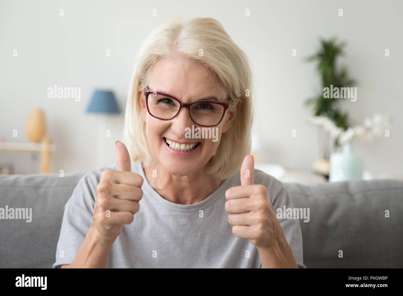 Excited elderly woman show thumbs up recommending something Stock Photo
