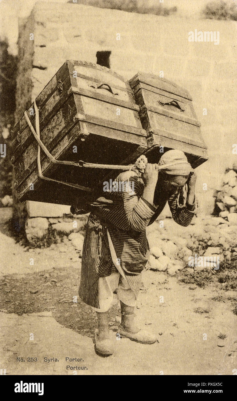 Syrian Porter carries two enormous trunks on his back. Stock Photo