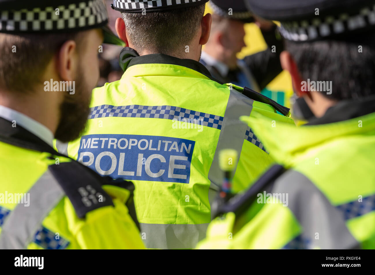 London, England; 20th October 2018; Rear view of Metropolitan Police Officers Wearing High Visibility Jackets in London Stock Photo