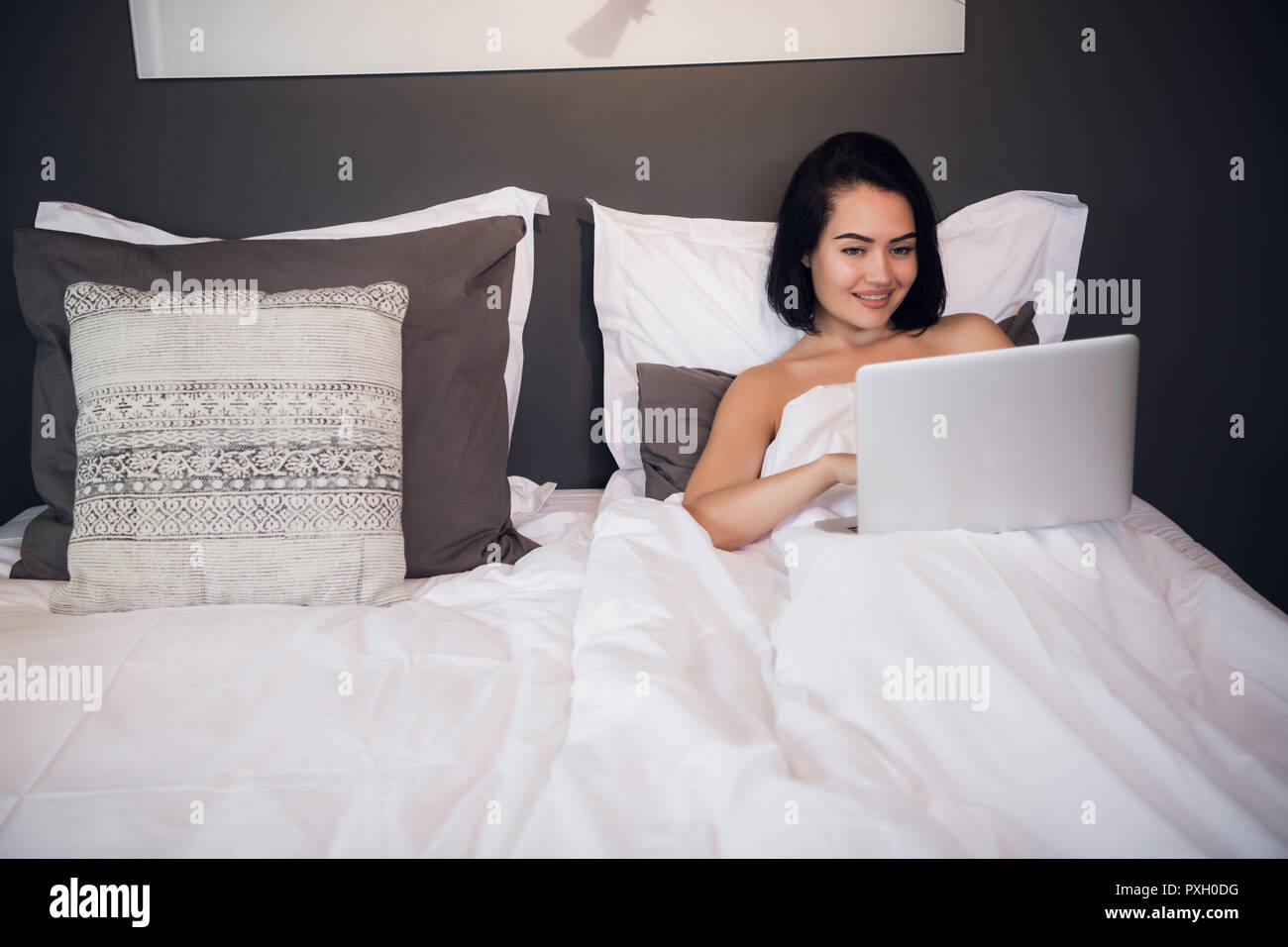 Portrait of beautiful young woman with laptop on bed Stock Photo - Alamy