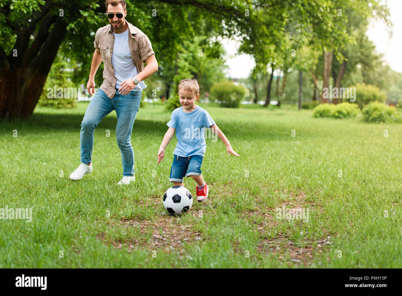 father and son playing football at park Stock Photo - Alamy