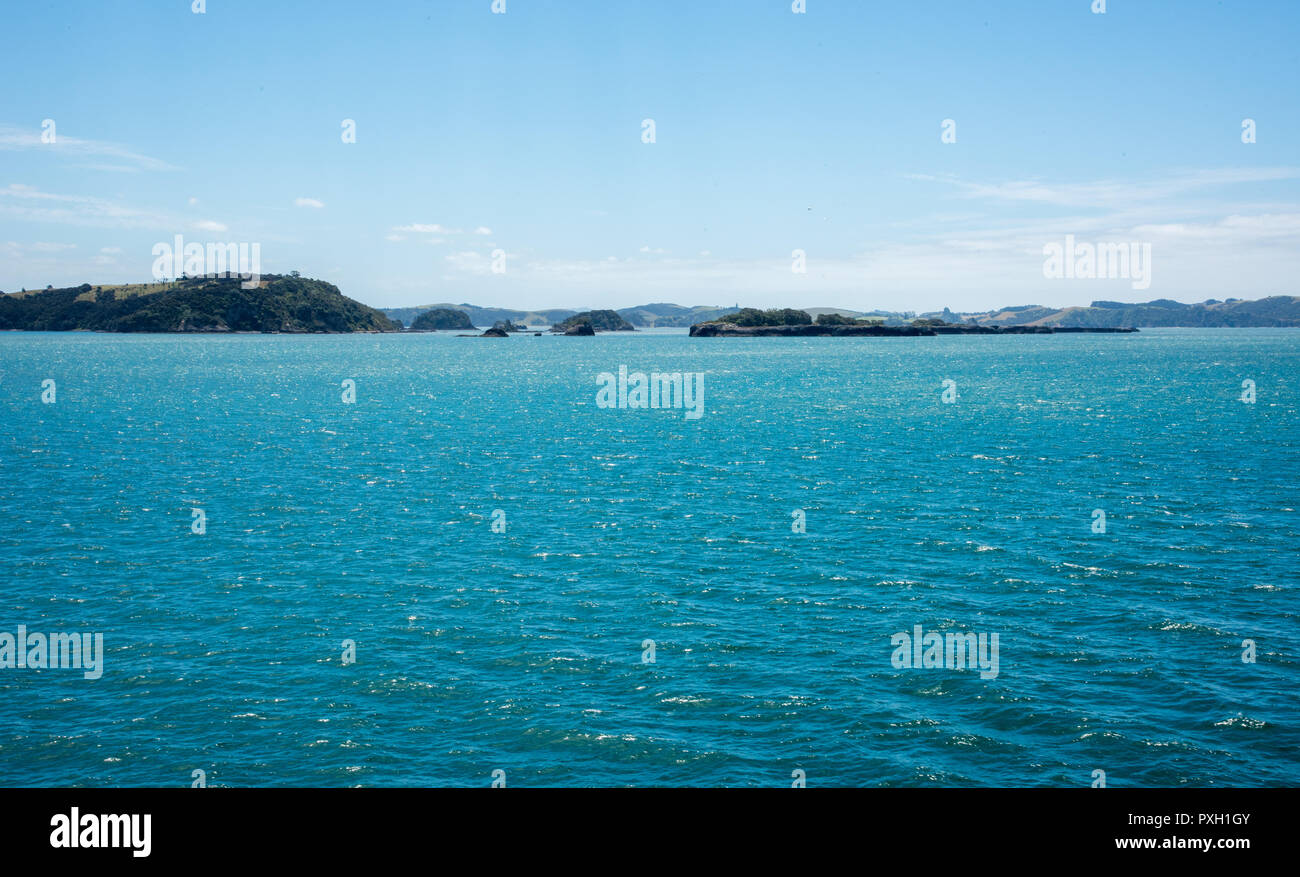 Stunning Bay of Islands with island landscapes under a blue sky surrounded by the Tasman Sea in remote New Zealand Stock Photo