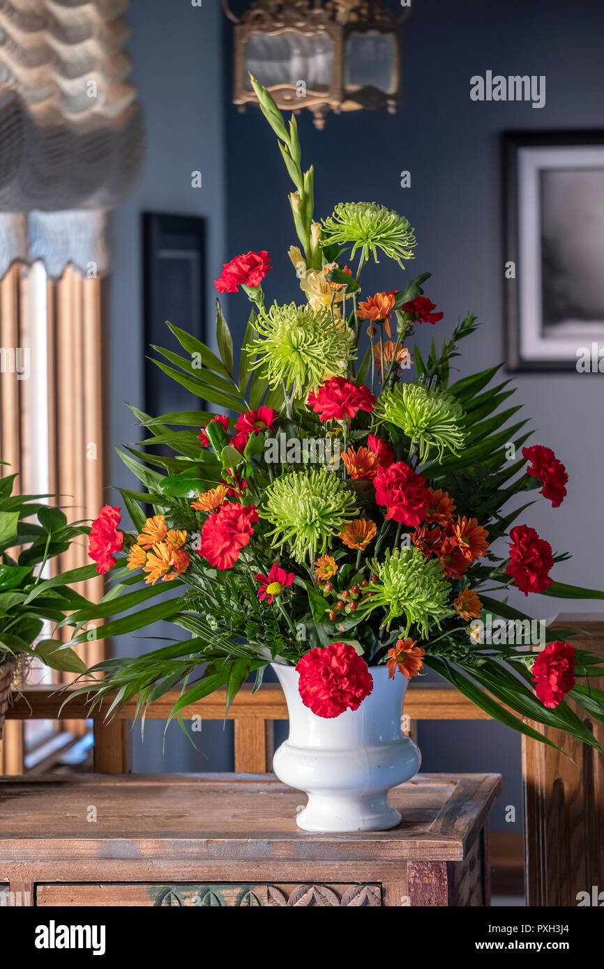 A bouquet of flowers in a white vase. Chrysanthemums and carnations. Stock Photo