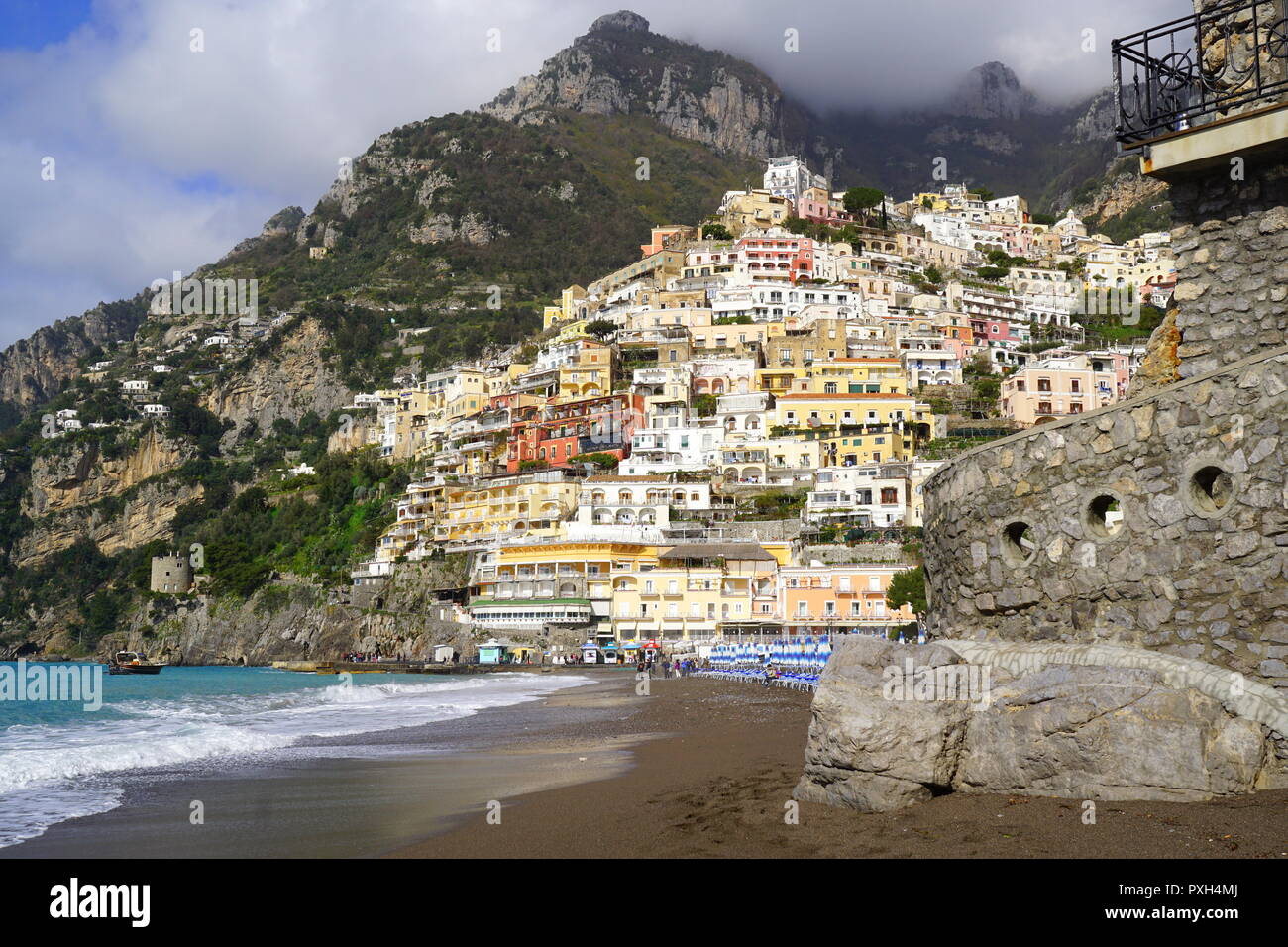 Beach with the backdrop of colorful homes on a steep mountain in Positano, a cliffside village on southern Italy's Amalfi Coast Stock Photo