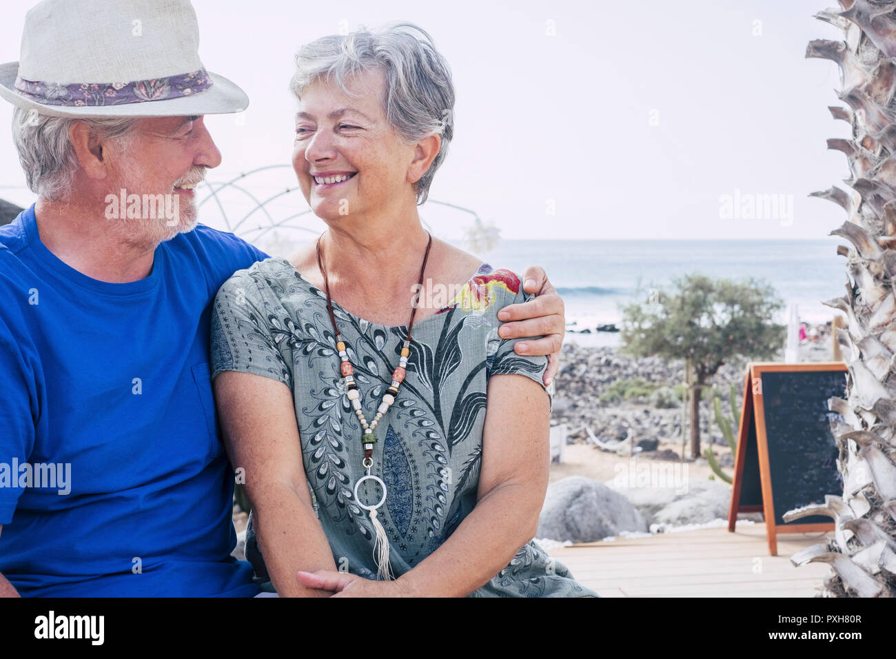 Happy senior couple laughing hugged on a summer day. concept of vacation, relaxation, rest. Blue sea in background. White clear sky and cheerful senio Stock Photo