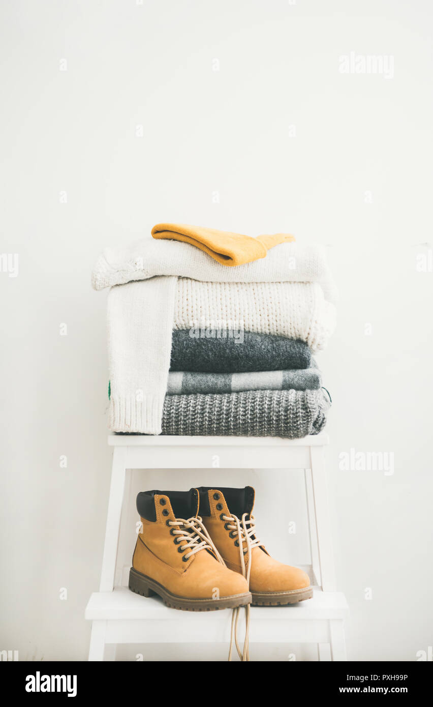 Pile of warm sweaters and blankets, cap and boots Stock Photo