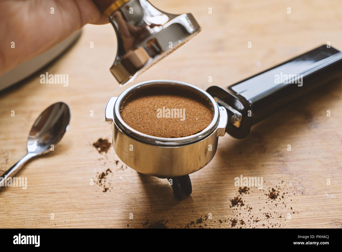 Top view of portafilter with ground coffee and hand hold tamper and