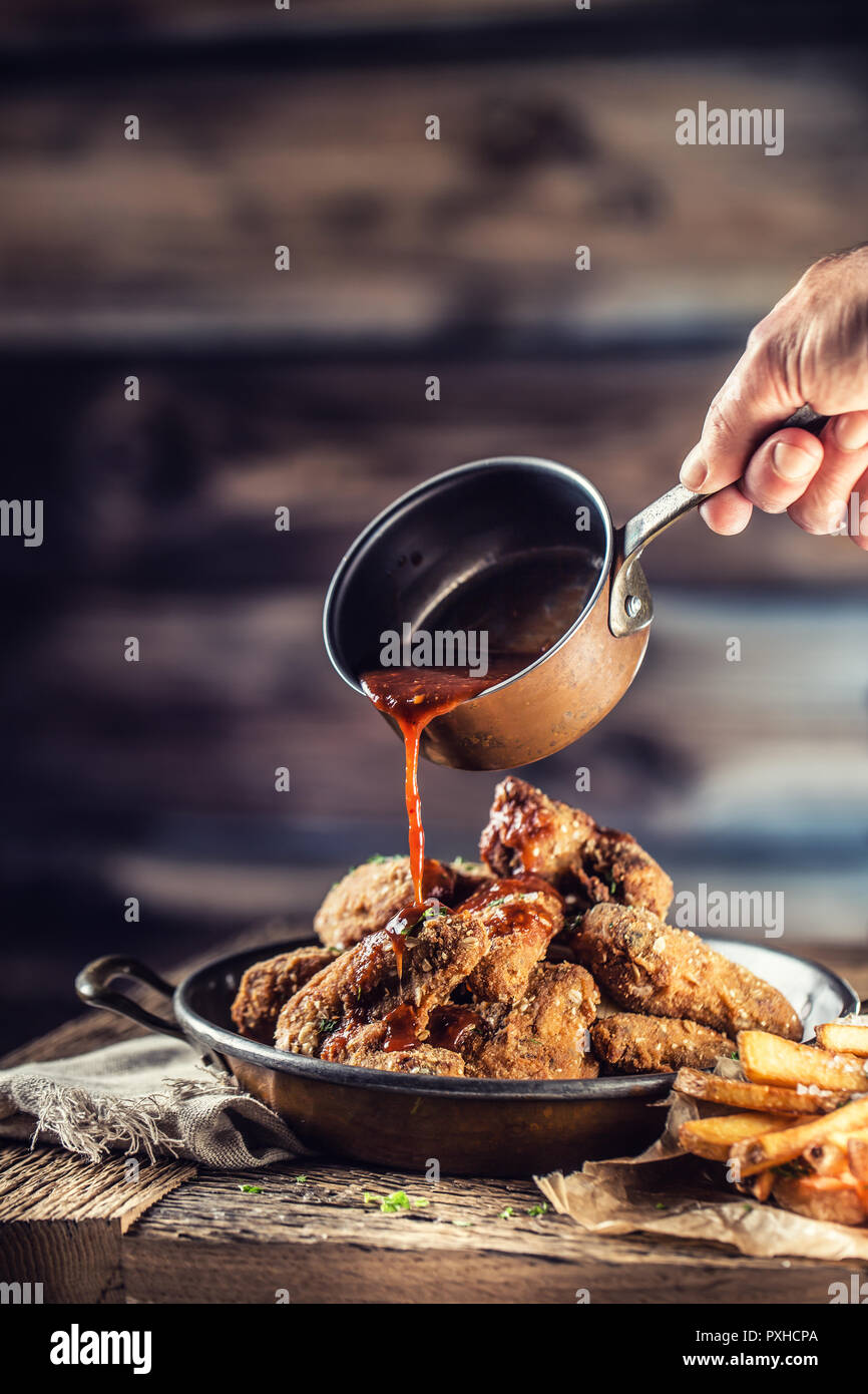 Fried chicken wings with fries on table in pub or restaurant. The chef