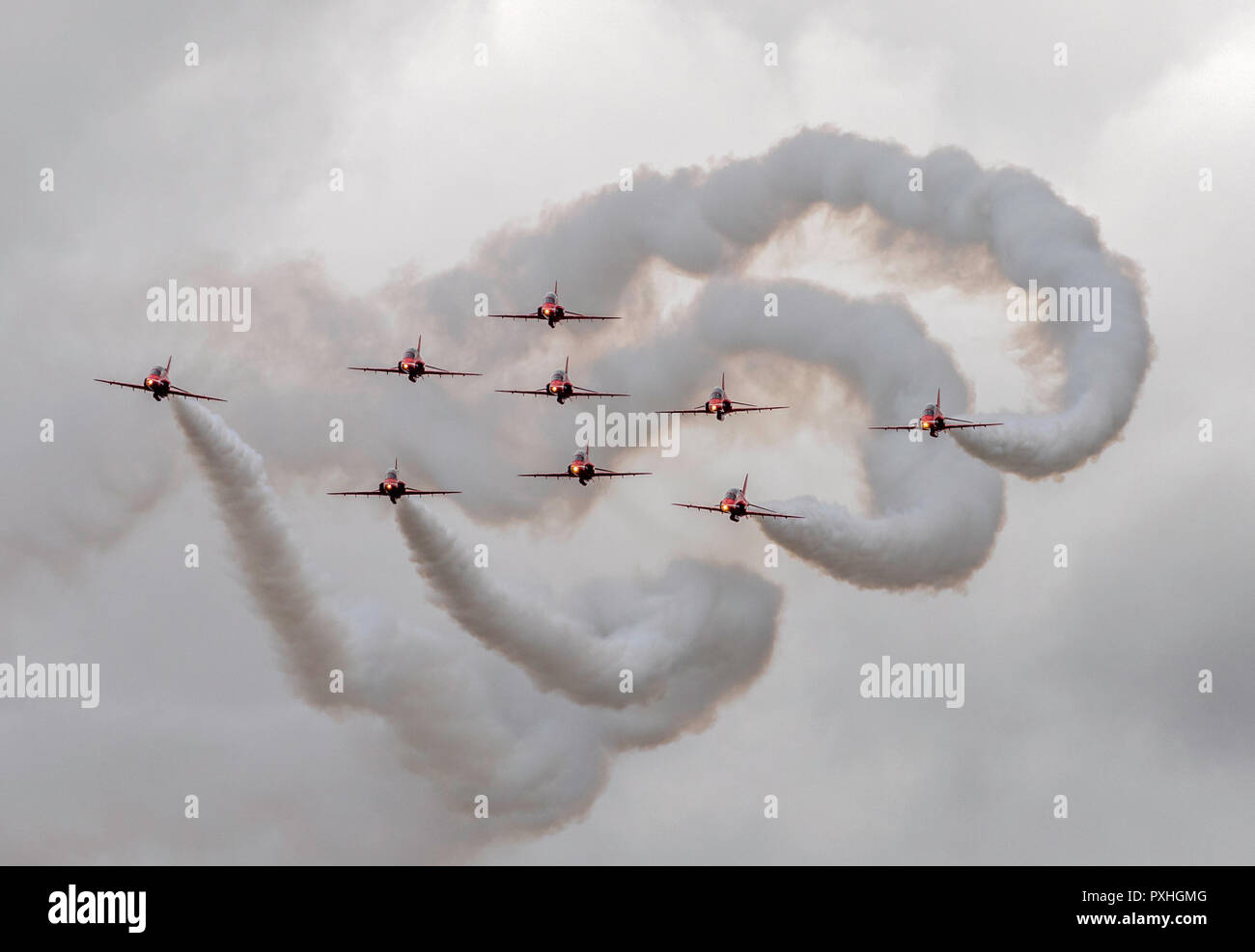 Nine Red Arrows Royal Airforce aerobatic display team with white smoke trails in flight over Highclere Castle, Berkshire, England Stock Photo
