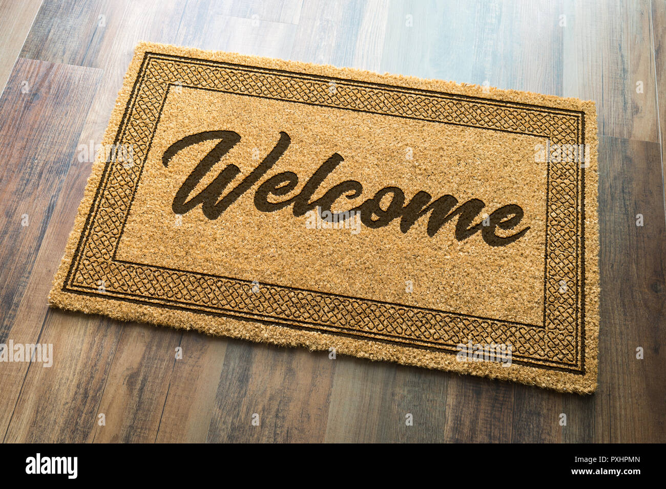 Welcome Mat On A Wood Floor Background. Stock Photo
