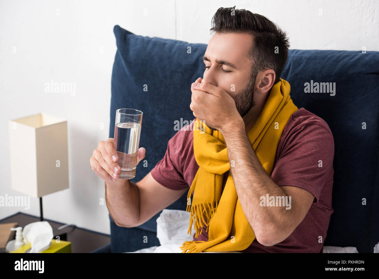 Sick Young Man Taking Pills While Sitting In Bed Sick Young Man Taking Pills While Sitting In Bed