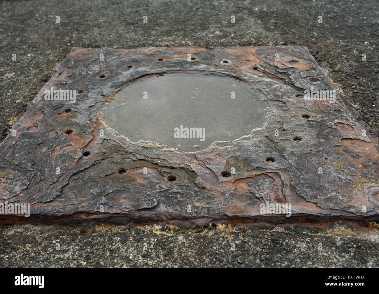Rusty steel plate with corrosion and delamination and water lying in