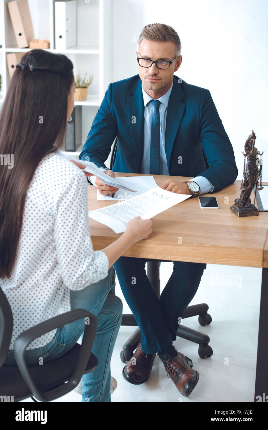 lawyer and client looking at each other while working with contract in ...
