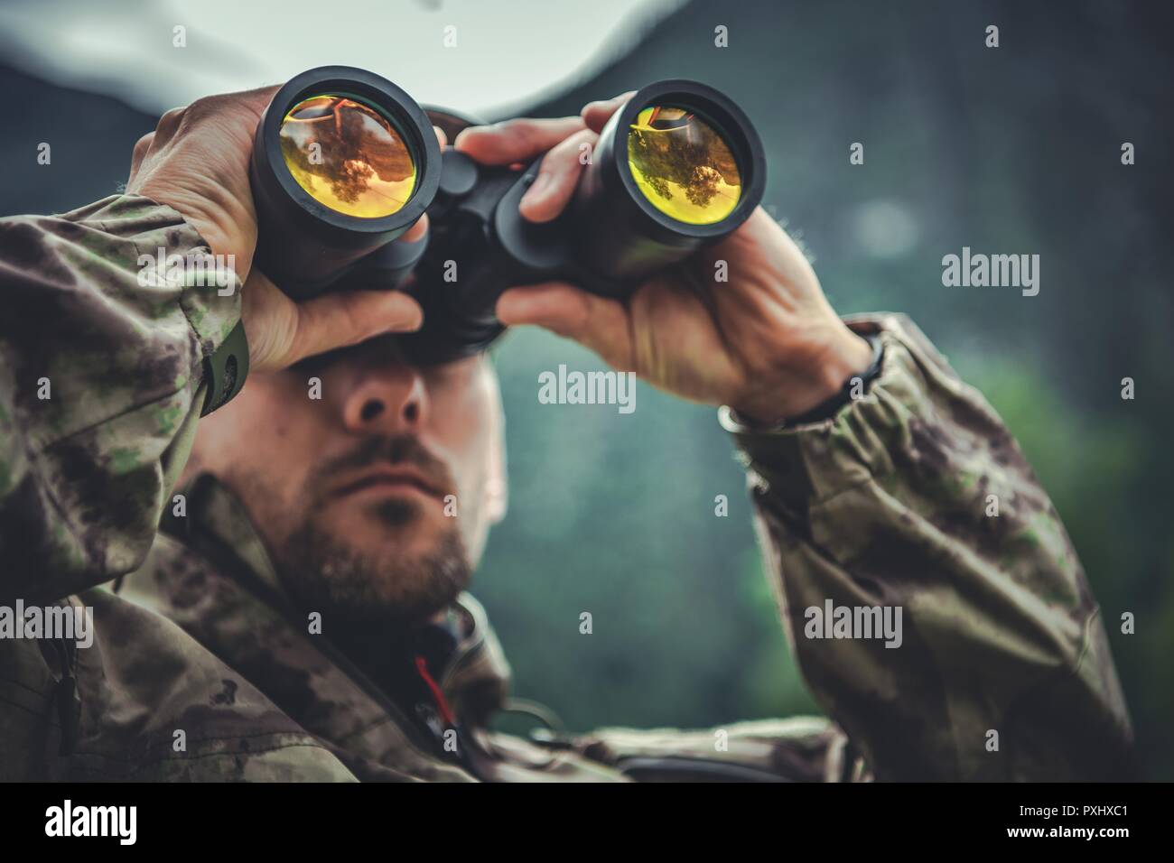 Caucasian Army Soldier in His 30s with Binoculars in Hands. Military Theme. Stock Photo