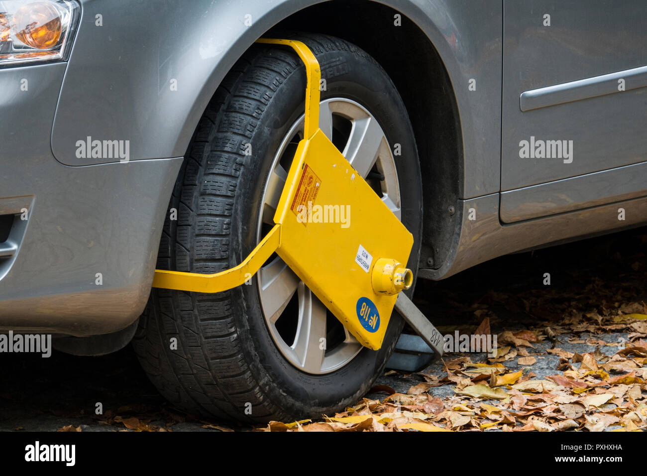Yellow wheel clamp on parked car in Plovdiv, Bulgaria Stock Photo