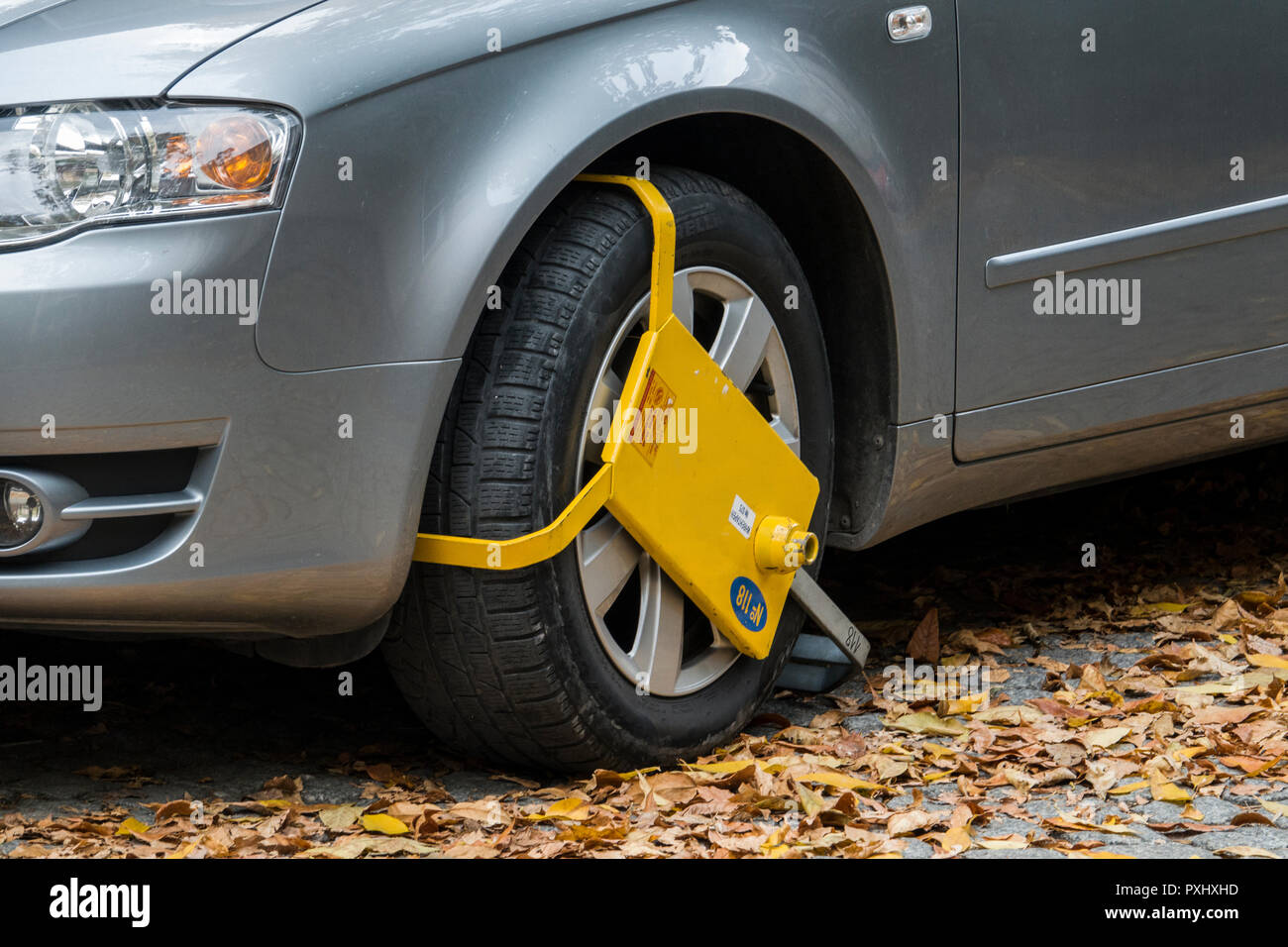 Yellow wheel clamp on parked car in Plovdiv, Bulgaria Stock Photo