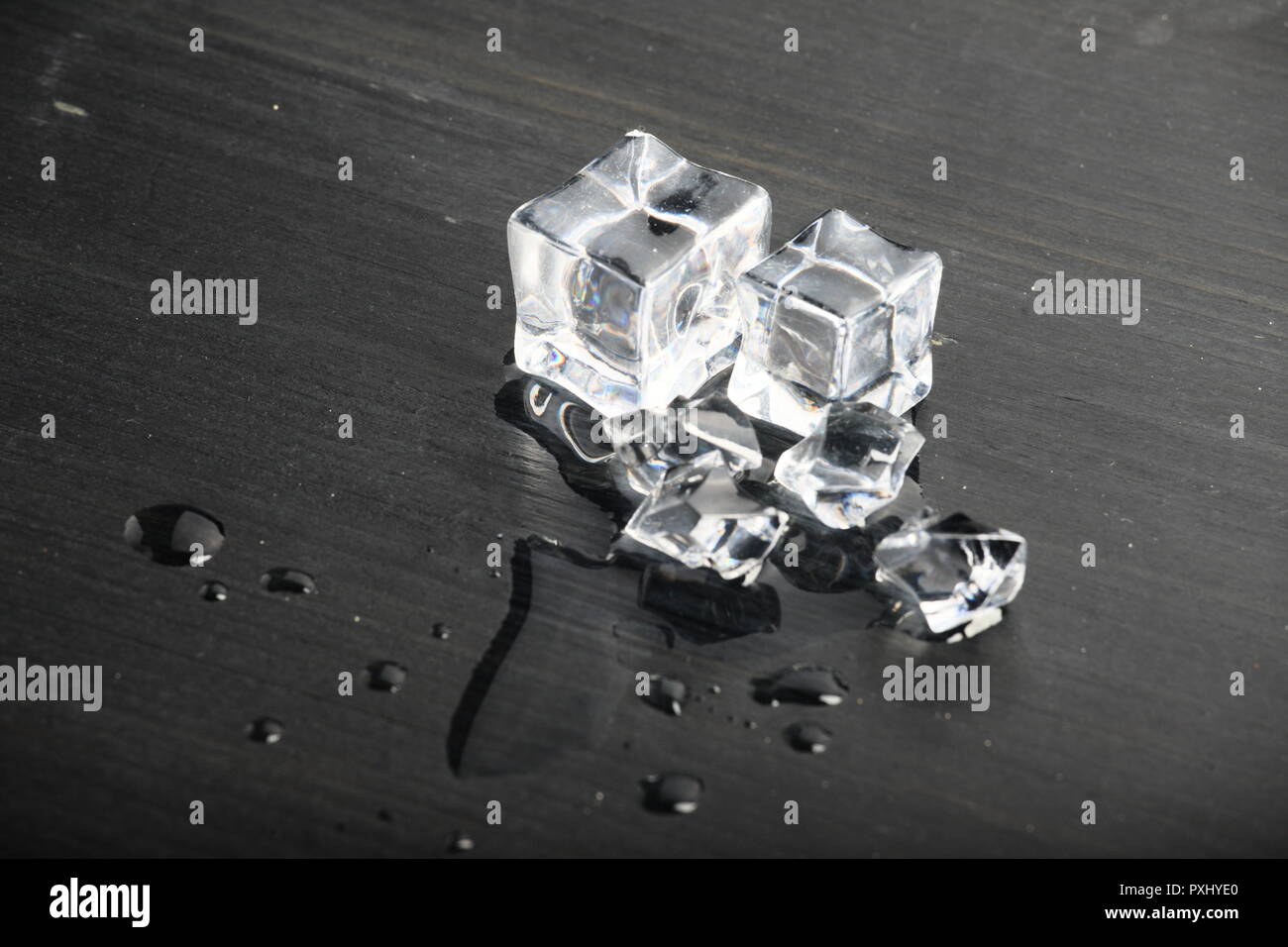 Melting ice on black surface Stock Photo - Alamy