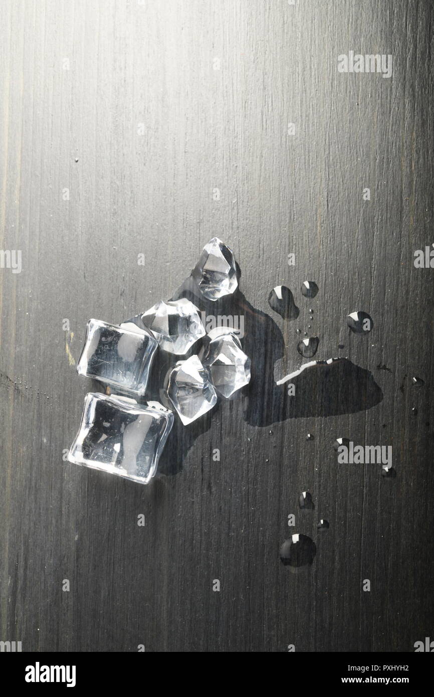 Melting ice on black surface Stock Photo - Alamy