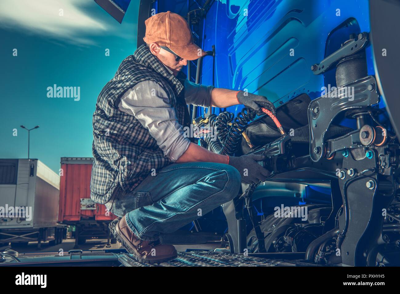 Semi Truck Maintenance. Caucasian Truck Mechanic Taking Care of Tractor