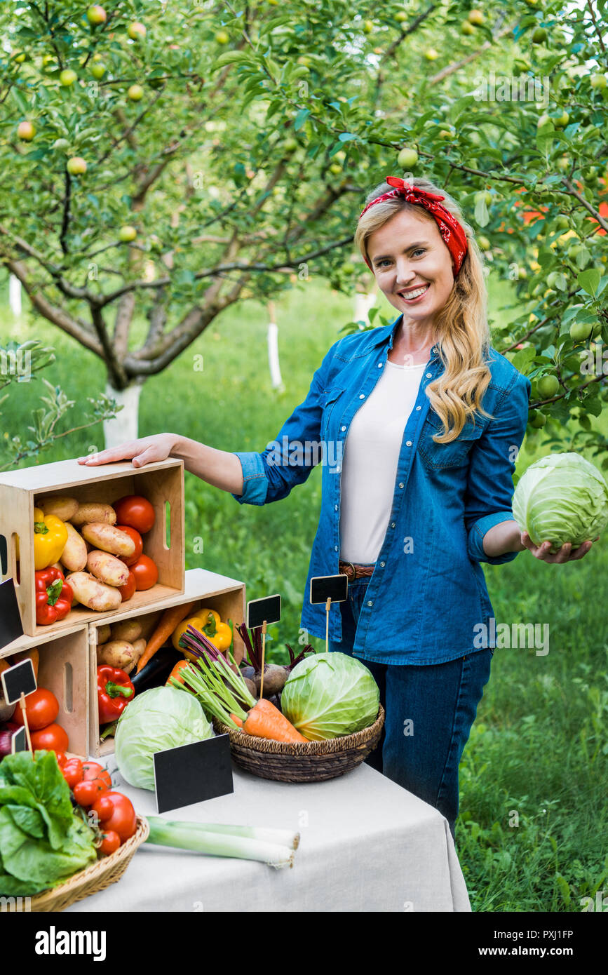 attractive farmer holding cabbage at farmer market Stock Photo