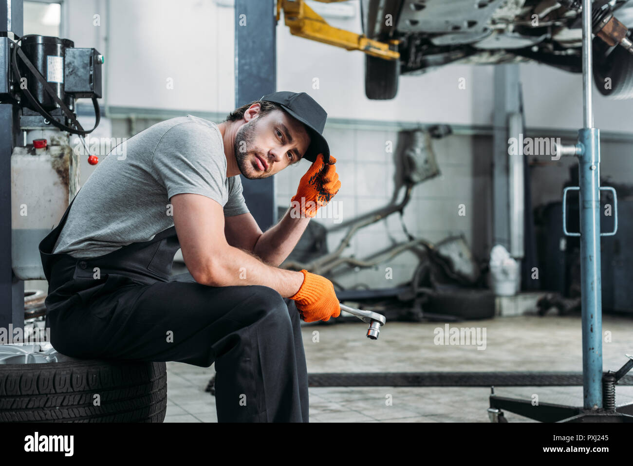 Auto mechanic sitting holding hi-res stock photography and images - Alamy