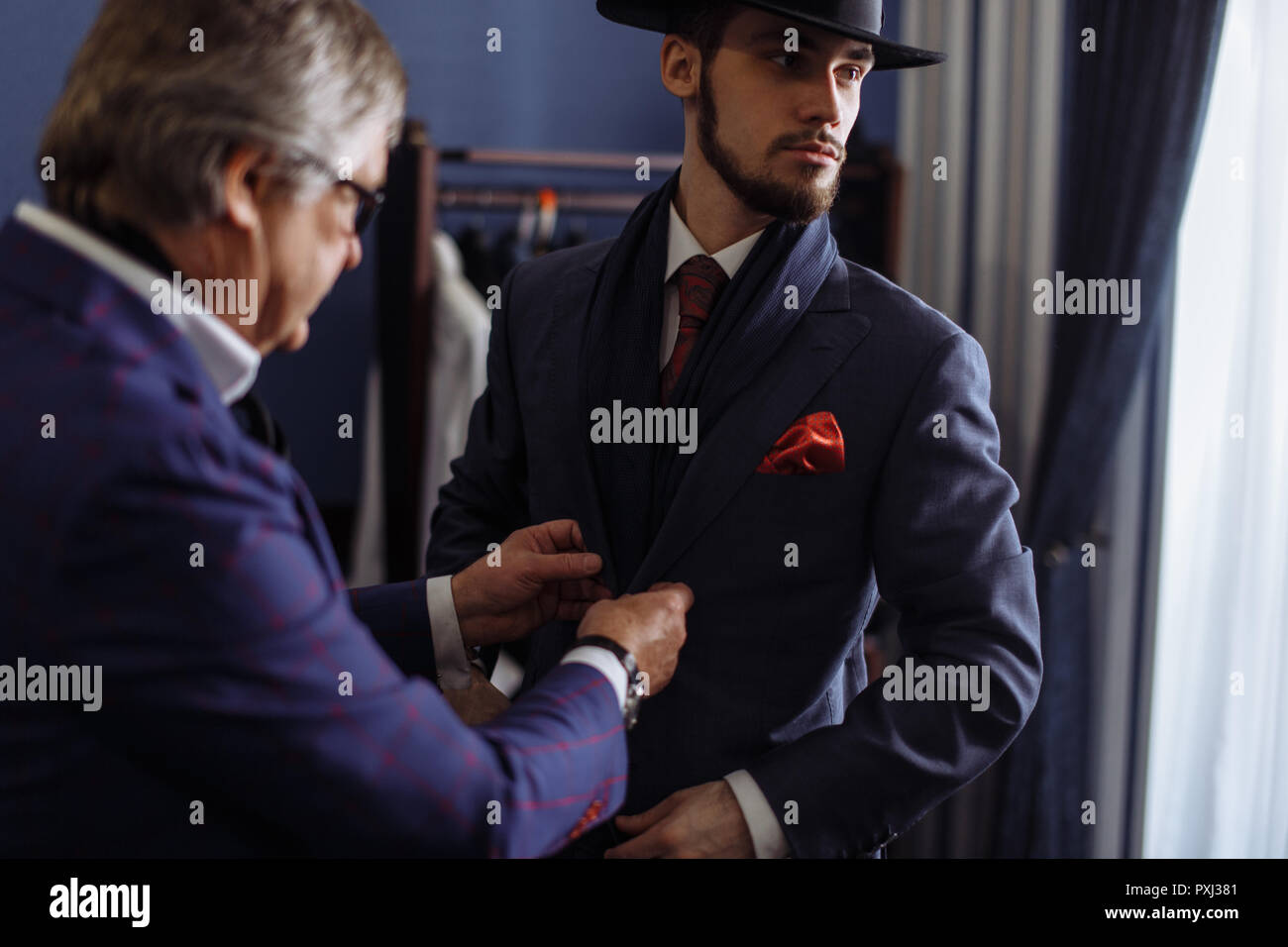 Tailor with client in atelier. Sewing custom made suit Stock Photo