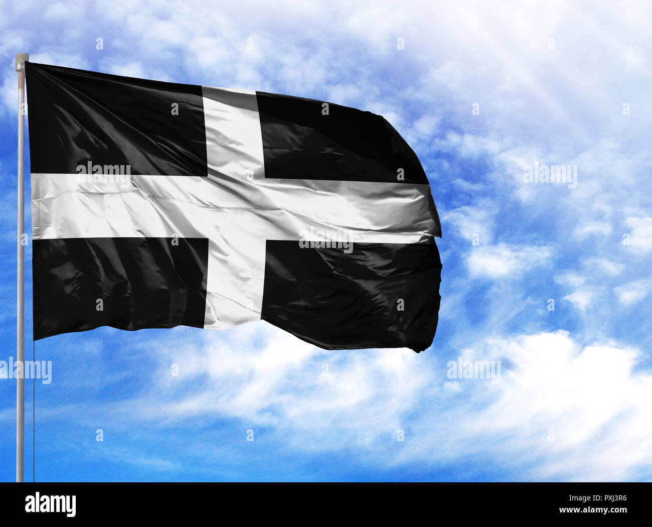 National flag of St Piran on a flagpole in front of blue sky. Stock Photo