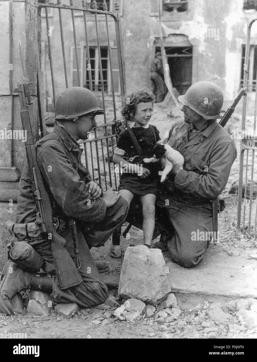 WW2 - US Troops comfort a distressed child and puppy - likely in France following the D-Day landings of June 1944.     Date: 1944 Stock Photo