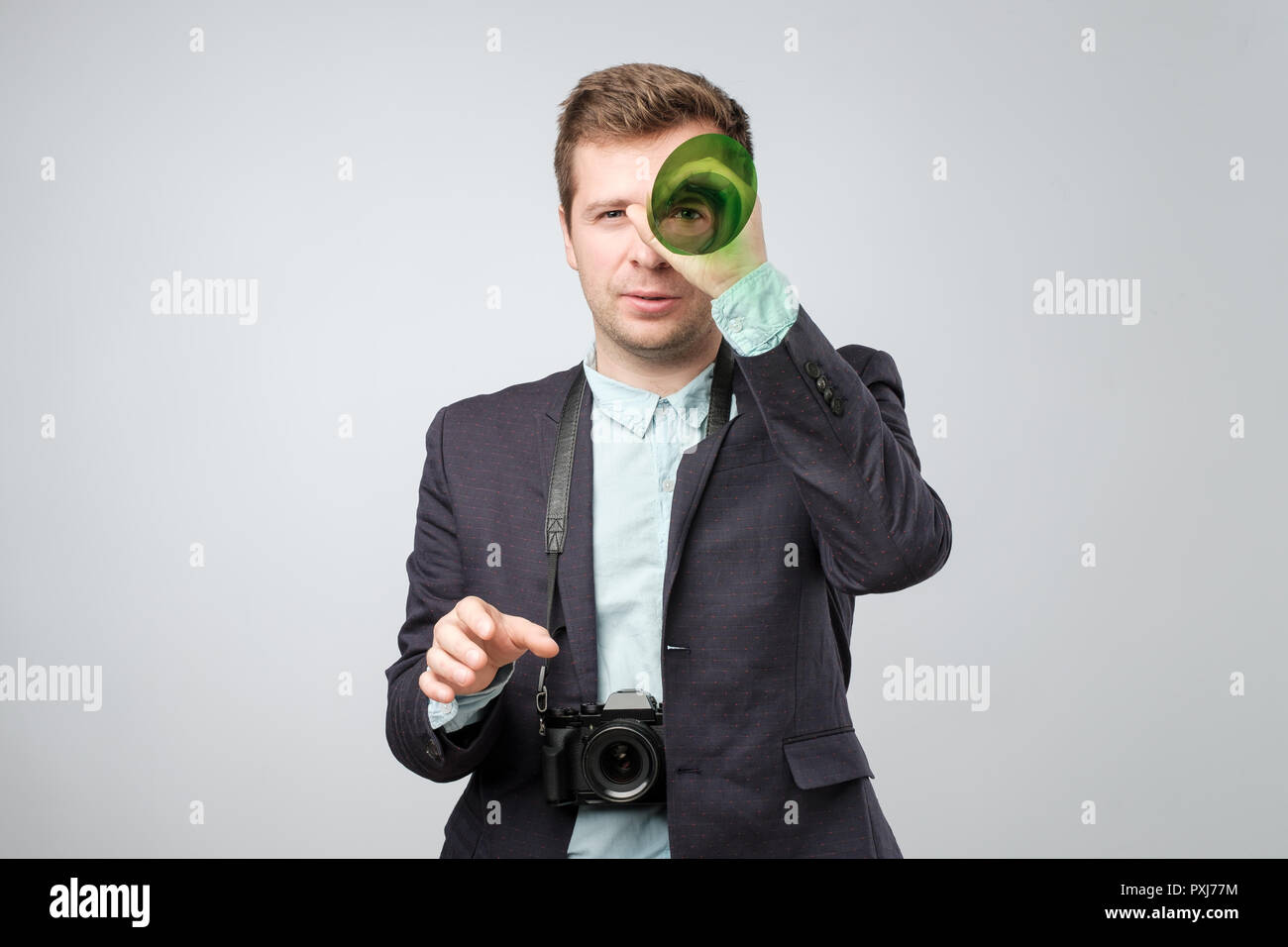 Handsome young man holding a photo camera. Studio shoot. Stock Photo
