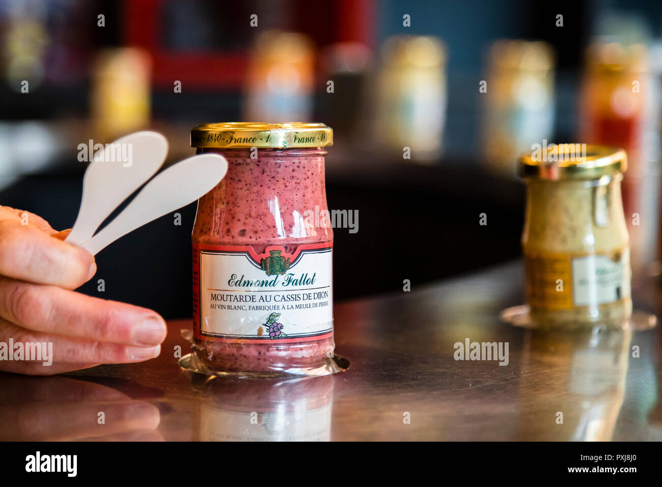 Tasting of the different types of mustard in the Edmont Fallot mustard fabrication in Beaune, France. Many of the flavored mustards still contain the mustard skins. They belong to the coarse mustards and are refined with other Burgundy specialties such as cassis, the black currant or with Pain d'Epices, gingerbread spices Stock Photo
