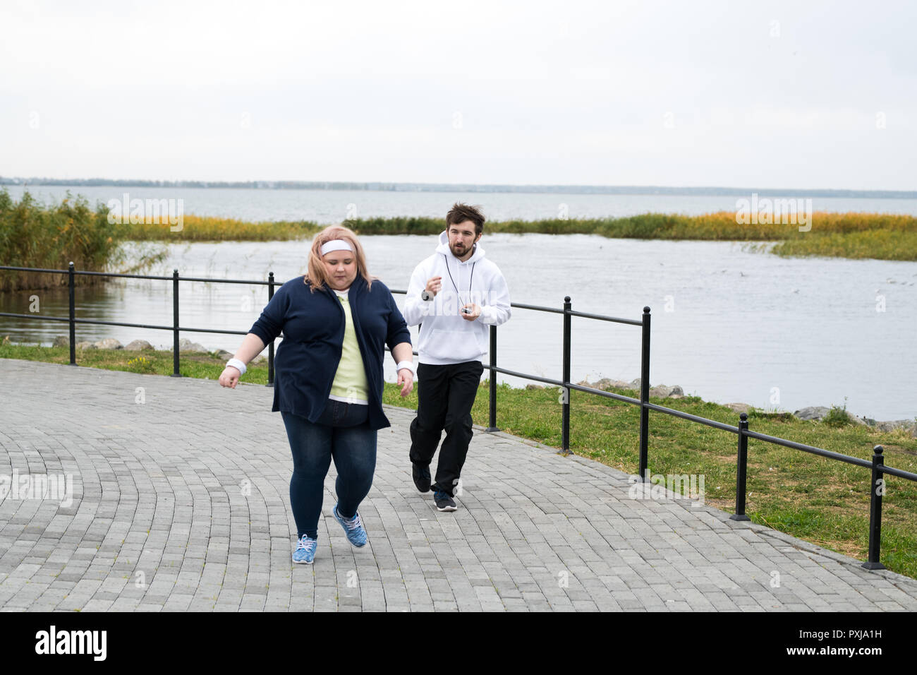 Overweight Woman Running in Park Stock Photo
