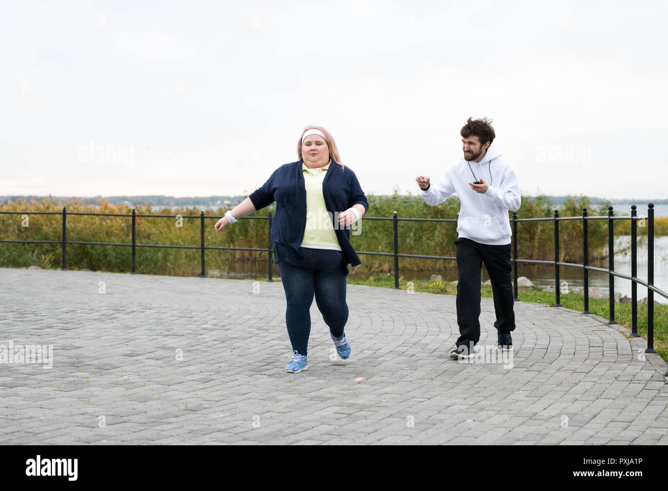 Overweight Woman Running Outdoors Stock Photo
