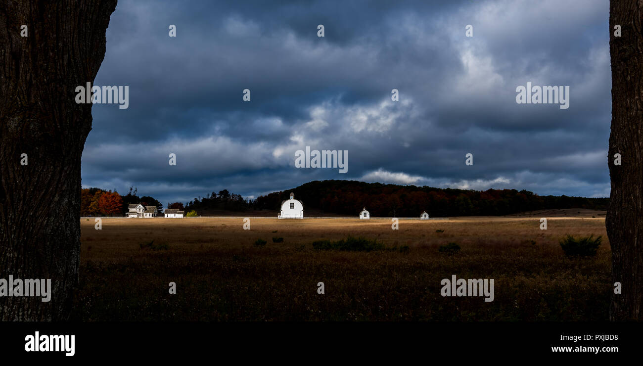 19th century white farm buildings on the historic The D.H. Day Farm with dramatic autumn skies. Sleeping Bear Dunes National Lakeshore, Michigan, USA. Stock Photo