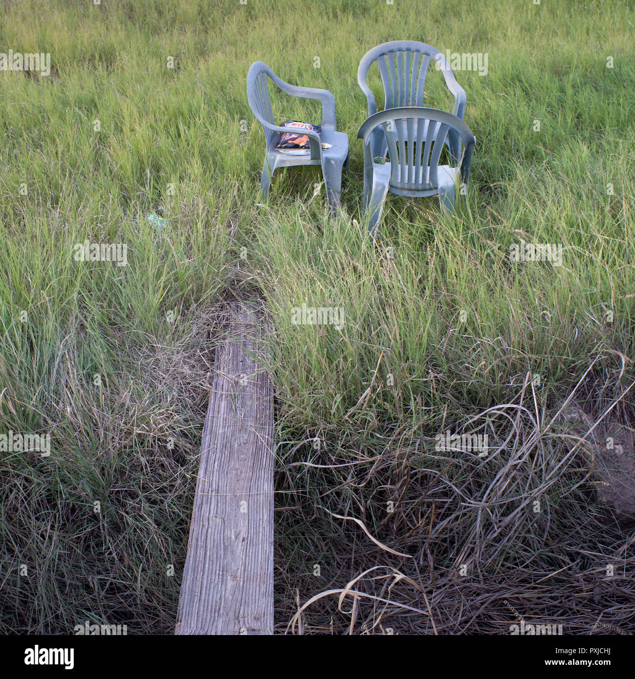 Three plastic chairs on a patch of grass in Alpine, Texas. Stock Photo