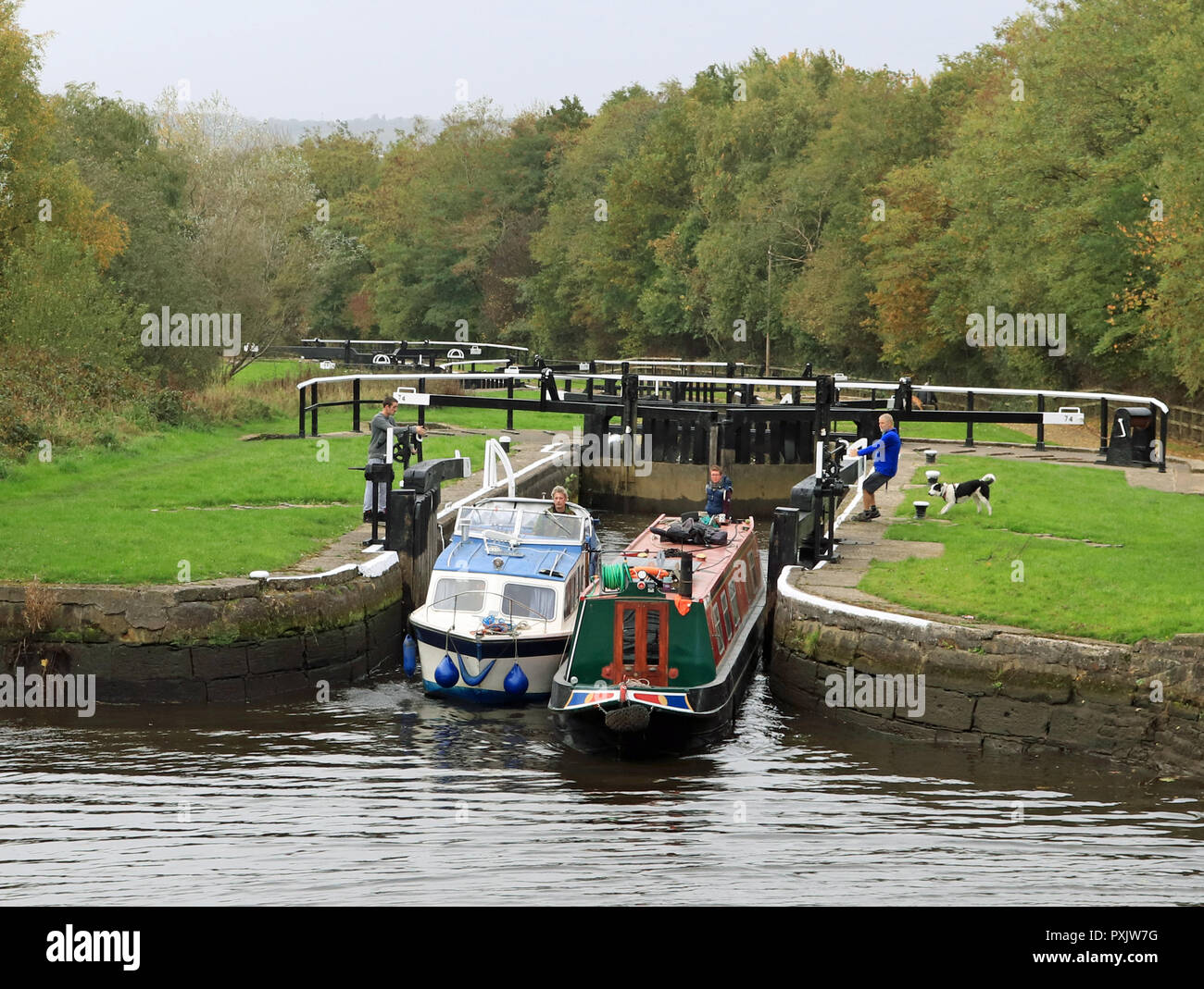 Leeds and Liverpool canal reopens, Wigan, England Wigan, Lancashire. 23rd October 2018. Two canal boats are leaving lock 74 on the long flight of locks up from Wigan to Aspull on The Leeds and Liverpool canal. This steel narrow boat and fibre glass cruiser where some of the 1st boats to ascend the flight of 21 locks following the reopening the previous afternoon.  The locks where closed back in July following the prolonged dry spell of weather in the spring and summer that meant the reservoirs that feed water to the canal became depleted of supplies. Cw 6438 Colin Wareing /Alamy Live news. Stock Photo