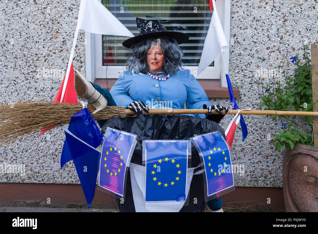 Theresa May scarecrow surrounded by european union flags depicted as the wicked witch of Brexit in a front garden as part of a scarecrow competition for Halloween Stock Photo