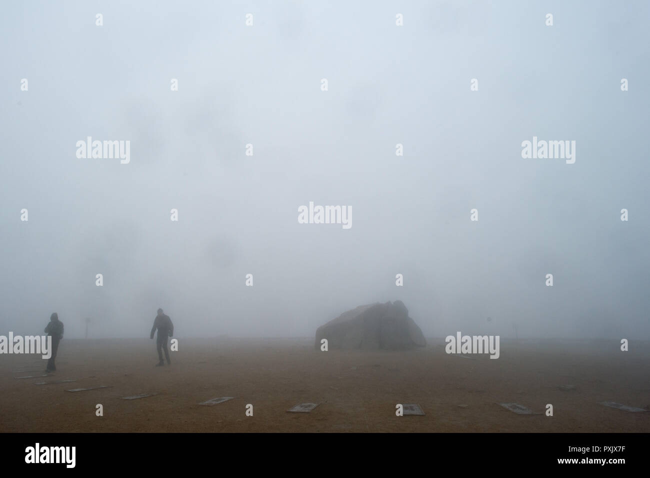 23 October 2018, Saxony-Anhalt, Brockengipfel: Hikers walk over the Brocken plateau in rain, fog and storm. The German Weather Service (DWD) has issued a thunderstorm warning for the Harz Mountains. The Harzer Schmalspurbahnen (HSB) have stopped the train service to the summit of the Brocken and are now only running to Drei Annen Hohne station. Photo: Klaus-Dietmar Gabbert/dpa-Zentralbild/dpa Stock Photo