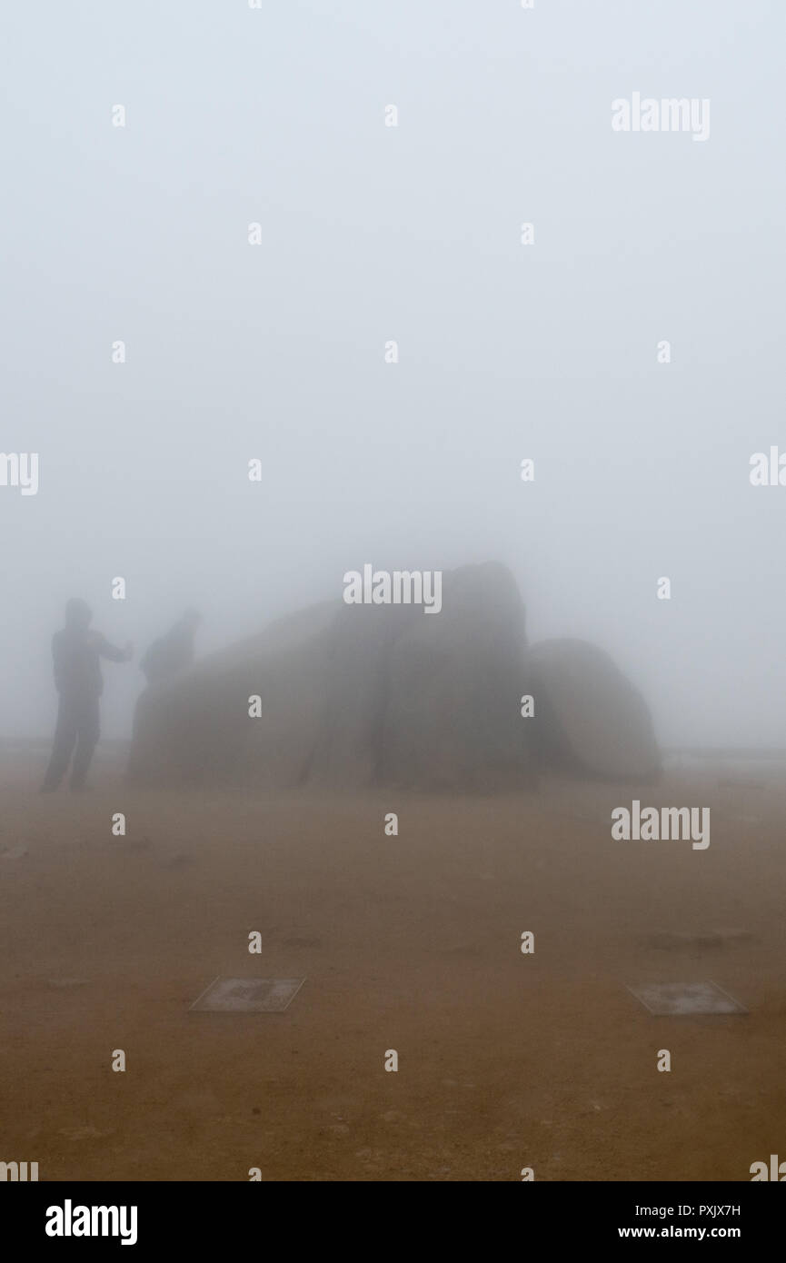 23 October 2018, Saxony-Anhalt, Brockengipfel: Hikers stand on the Brocken plateau during rain, fog and storm. The German Weather Service (DWD) has issued a thunderstorm warning for the Harz Mountains. The Harzer Schmalspurbahnen (HSB) have stopped the train service to the summit of the Brocken and are now only running to Drei Annen Hohne station. Photo: Klaus-Dietmar Gabbert/dpa-Zentralbild/dpa Stock Photo
