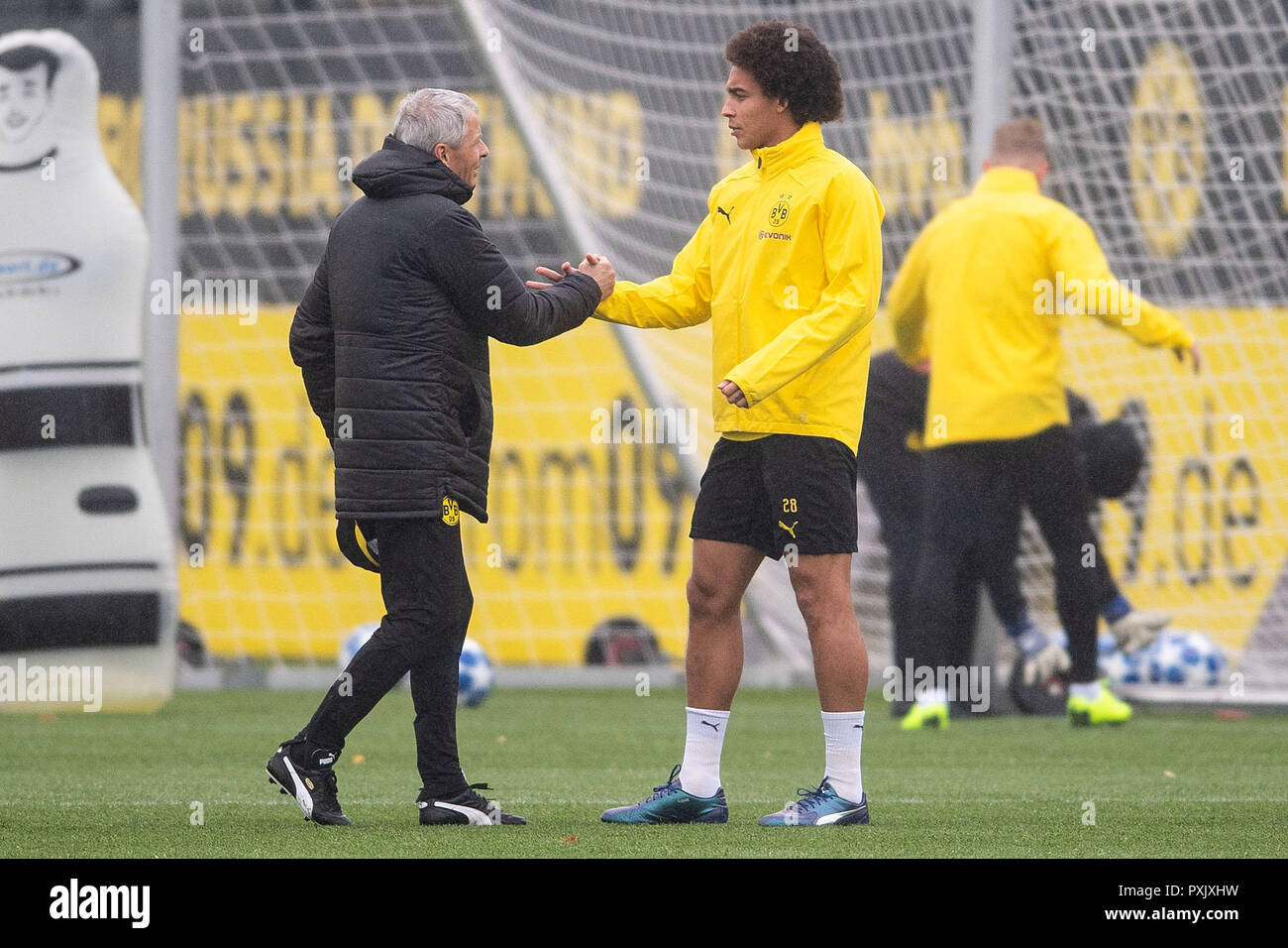 Dortmund, Germany. 23rd Oct, 2018. Dortmund coach Lucien Favre (l) welcomes player Axel Witsel before the training. BVB will face Atletico Madrid on the 3rd matchday of Group A of the Champions League. Credit: Marius Becker/dpa/Alamy Live News Stock Photo
