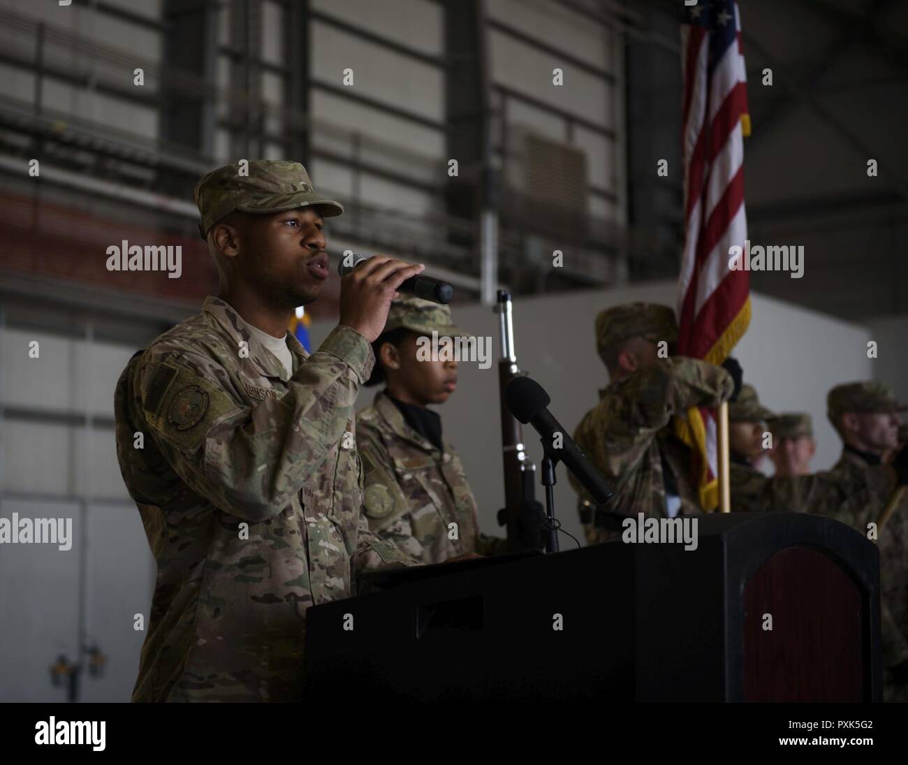 Senior Airman Calvin Johnson, 455th Expeditionary Security Forces Squadron, sings the national anthem during a change of command ceremony at Bagram Airfield, Afghanistan, June 3, 2017. During the ceremony, Brig. Gen. Jim Sears relinquished command of the 455th Air Expeditionary Wing to Brig. Gen. Craig Baker. Stock Photo