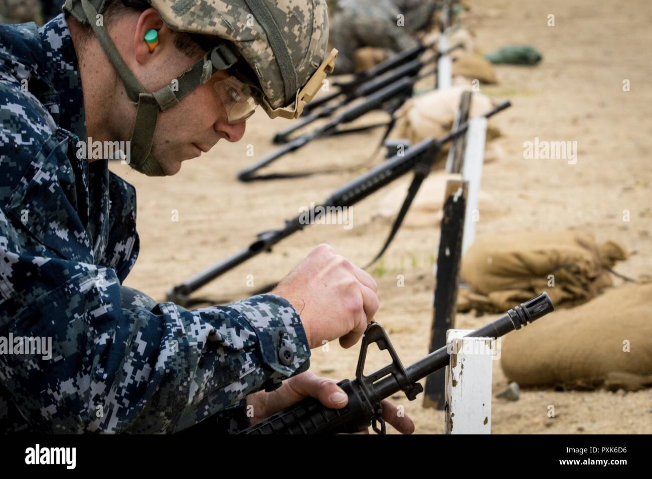 Ensign David Segala, an Engineer Duty Officer from New London, CT adjusts his front sights