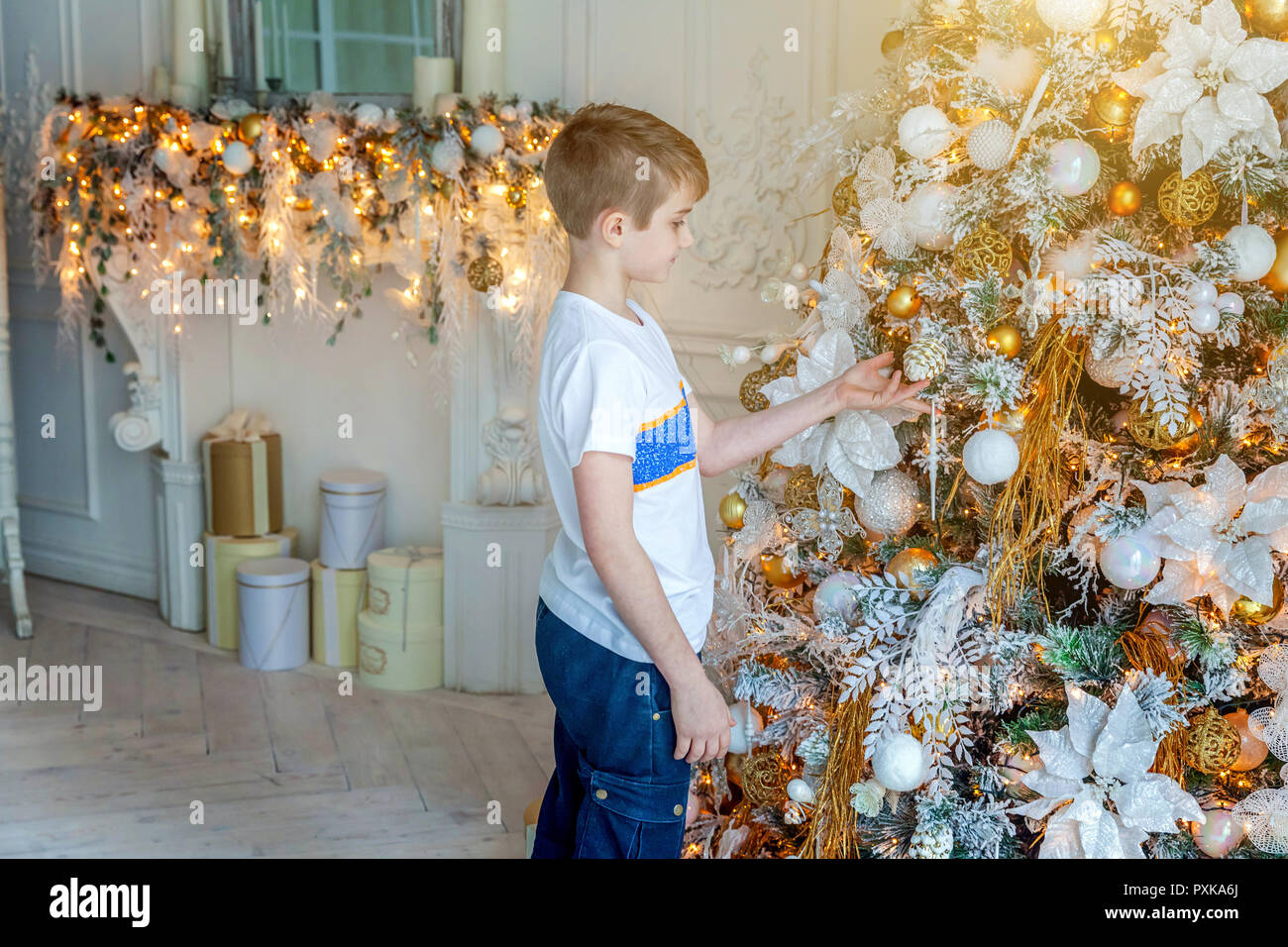 Little Boy Decorating Christmas Tree On Christmas Eve At Home